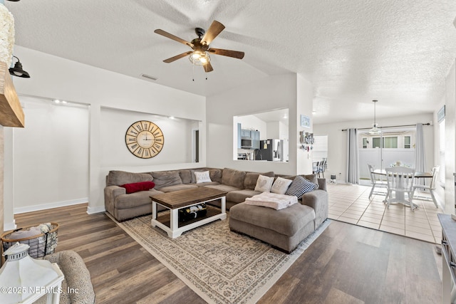 living room featuring ceiling fan, hardwood / wood-style floors, and a textured ceiling