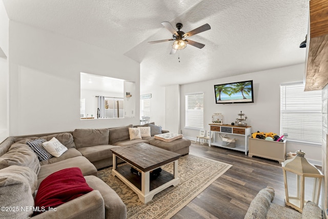 living room featuring dark hardwood / wood-style flooring, ceiling fan, and a textured ceiling