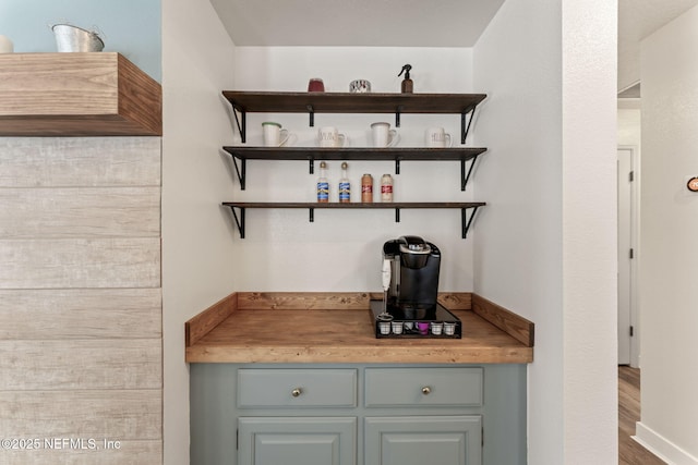 bar featuring gray cabinetry and wooden counters