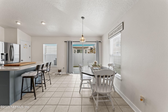 dining room with light tile patterned flooring and a textured ceiling