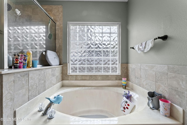 bathroom featuring plus walk in shower and plenty of natural light