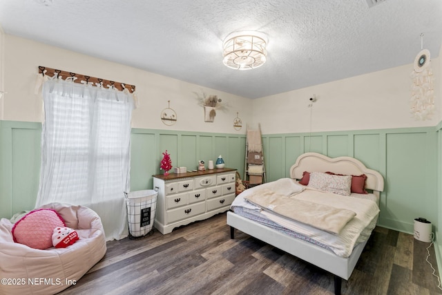 bedroom featuring dark hardwood / wood-style flooring and a textured ceiling