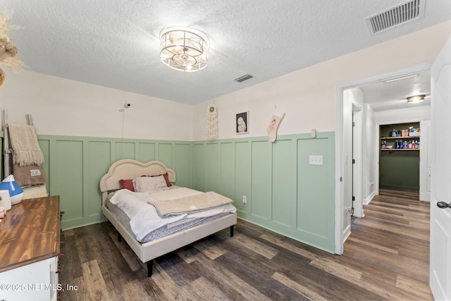 bedroom with dark hardwood / wood-style flooring and a textured ceiling