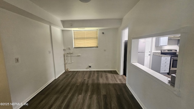 corridor featuring dark wood-style floors and baseboards