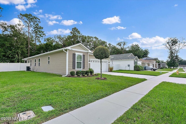 view of front of house featuring a front lawn, a garage, and central AC