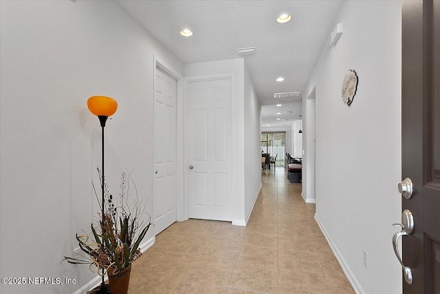 hall with light tile patterned floors