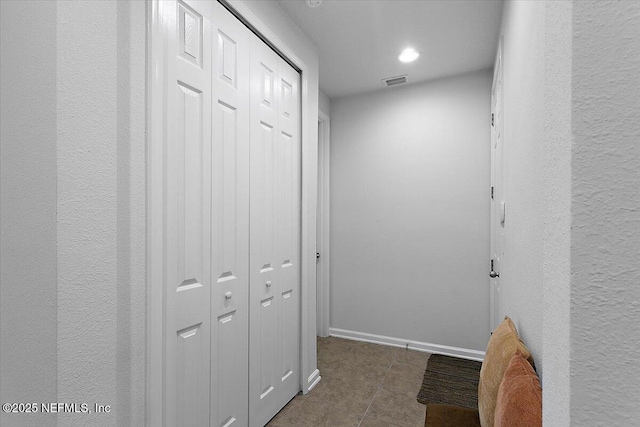 hall featuring dark tile patterned floors