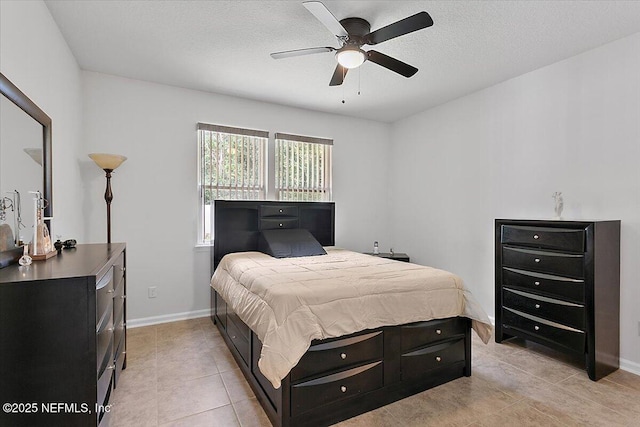 tiled bedroom with ceiling fan and a textured ceiling