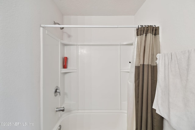 bathroom with shower / tub combo with curtain and a textured ceiling