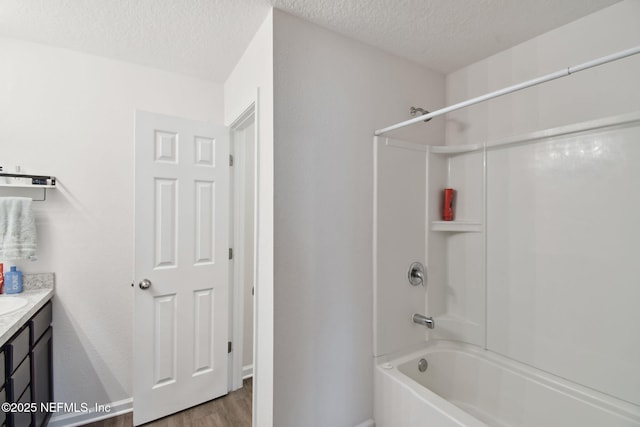 bathroom featuring hardwood / wood-style flooring, a textured ceiling, vanity, and shower / bathtub combination