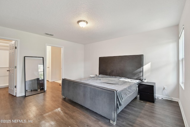 bedroom featuring dark hardwood / wood-style flooring and a textured ceiling