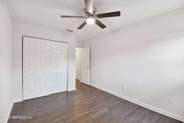 unfurnished bedroom with ceiling fan, a closet, and dark hardwood / wood-style floors