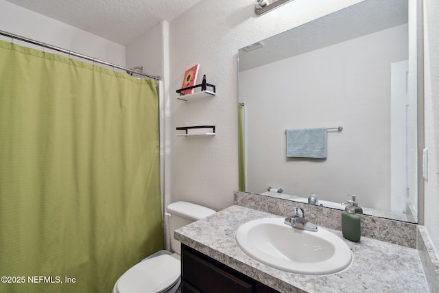 bathroom with a textured ceiling, toilet, and vanity