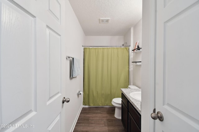 full bathroom with a textured ceiling, wood-type flooring, vanity, toilet, and shower / bath combo with shower curtain