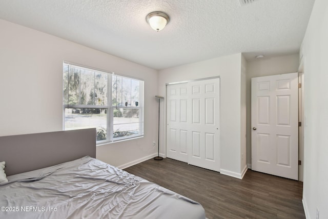 bedroom with dark wood-type flooring, a closet, and a textured ceiling