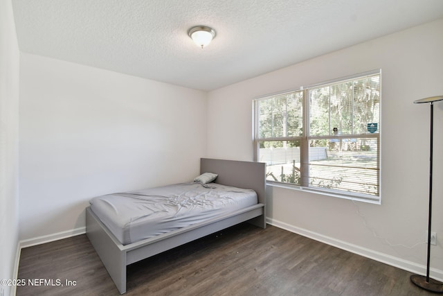 bedroom with dark hardwood / wood-style floors