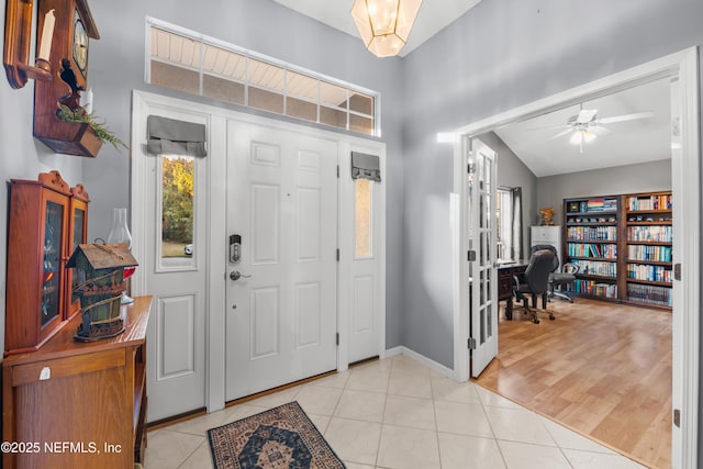 tiled entryway with ceiling fan and lofted ceiling