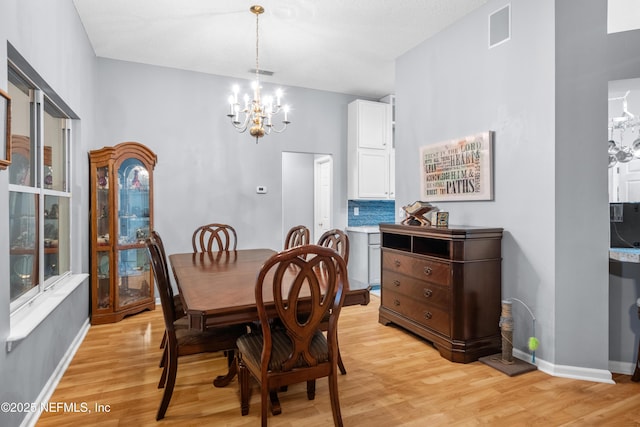 dining area featuring an inviting chandelier and light hardwood / wood-style flooring