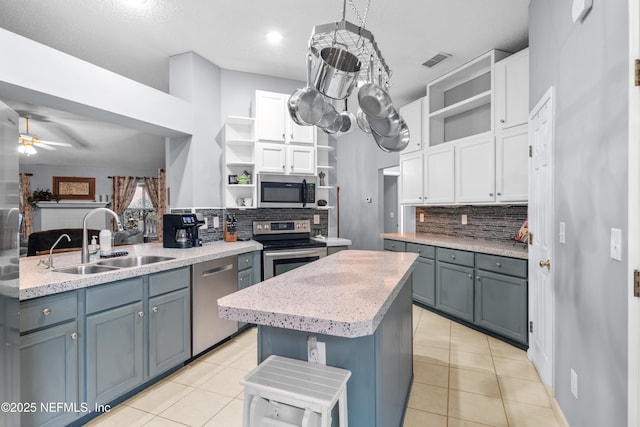 kitchen with sink, white cabinets, appliances with stainless steel finishes, and a center island