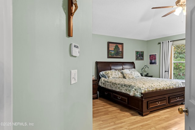 bedroom featuring ceiling fan, lofted ceiling, and light hardwood / wood-style floors