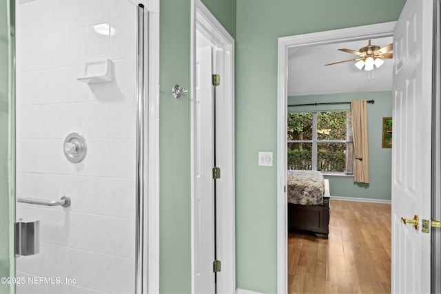 bathroom featuring walk in shower, ceiling fan, and hardwood / wood-style flooring