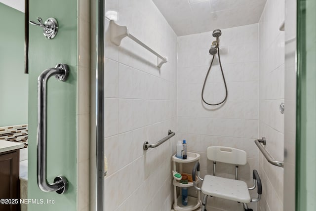 bathroom with tile walls, an enclosed shower, vanity, and tasteful backsplash