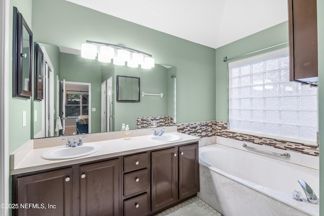 bathroom with tile patterned flooring, a washtub, and vanity