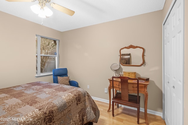 bedroom featuring ceiling fan, light hardwood / wood-style floors, and a closet