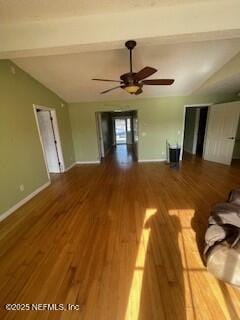 unfurnished living room featuring hardwood / wood-style flooring, ceiling fan, and beam ceiling