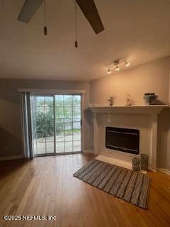 3706 Sanctuary Way N, Jacksonville Beach, FL 32250 - unfurnished living room featuring a glass covered fireplace, wood finished floors, and baseboards