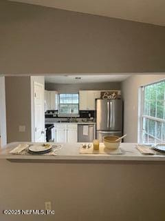 3706 Sanctuary Way N, Jacksonville Beach, FL 32250 - kitchen with stainless steel appliances, white cabinets, and light countertops