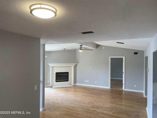 3706 Sanctuary Way N, Jacksonville Beach, FL 32250 - unfurnished living room featuring a ceiling fan, wood finished floors, vaulted ceiling, a textured ceiling, and baseboards