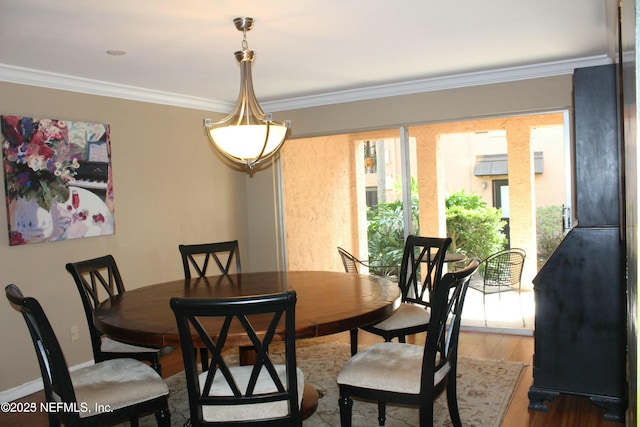 dining area with hardwood / wood-style floors and ornamental molding