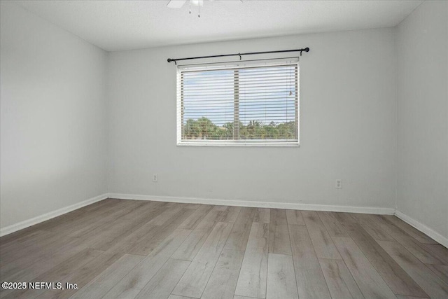 empty room featuring ceiling fan and light hardwood / wood-style flooring