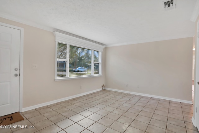 spare room featuring a textured ceiling, light tile patterned flooring, and crown molding