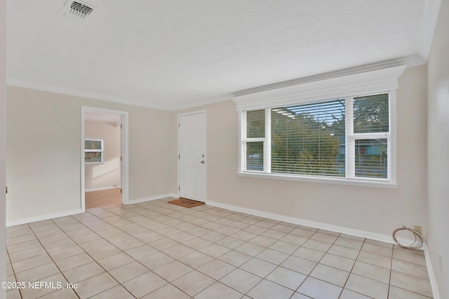 unfurnished room with light tile patterned flooring, crown molding, and a healthy amount of sunlight