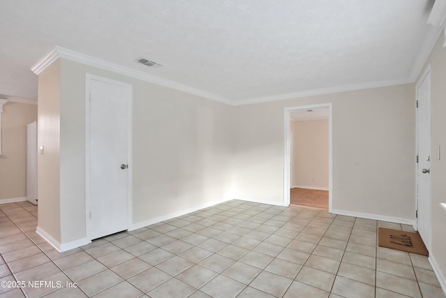 spare room featuring light tile patterned floors and ornamental molding