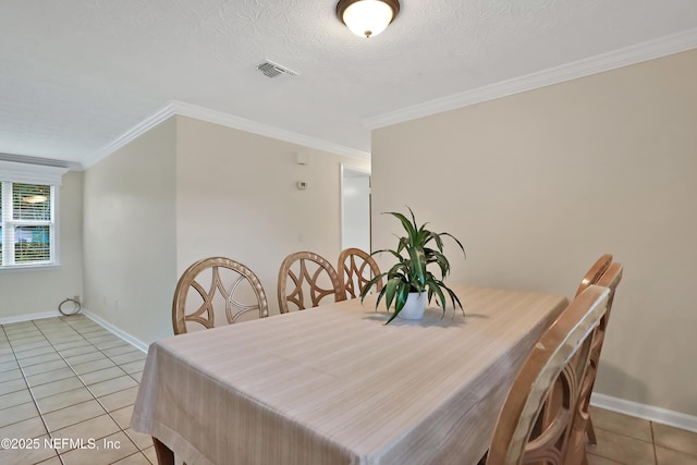 dining space with a textured ceiling, light tile patterned floors, and ornamental molding