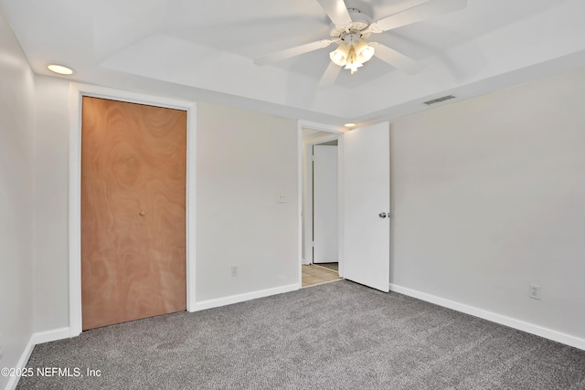 unfurnished bedroom featuring ceiling fan, a closet, and light colored carpet