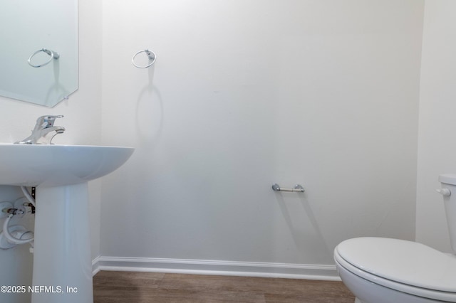 bathroom with wood-type flooring and toilet