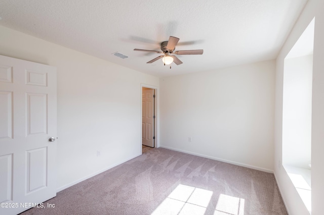 carpeted empty room featuring ceiling fan and a textured ceiling