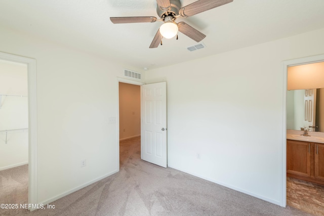 unfurnished bedroom with light carpet, sink, and connected bathroom