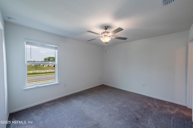 carpeted empty room with ceiling fan and a textured ceiling