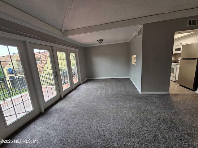 carpeted spare room with vaulted ceiling and french doors