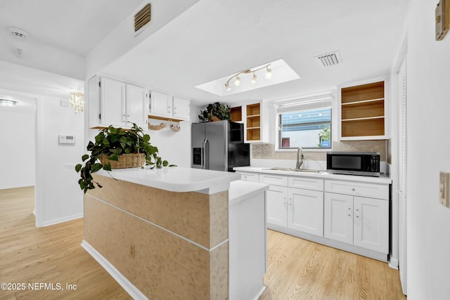 kitchen featuring white cabinets, appliances with stainless steel finishes, light hardwood / wood-style flooring, and sink