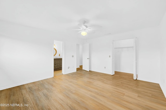 unfurnished bedroom with ensuite bathroom, a closet, light wood-type flooring, and ceiling fan