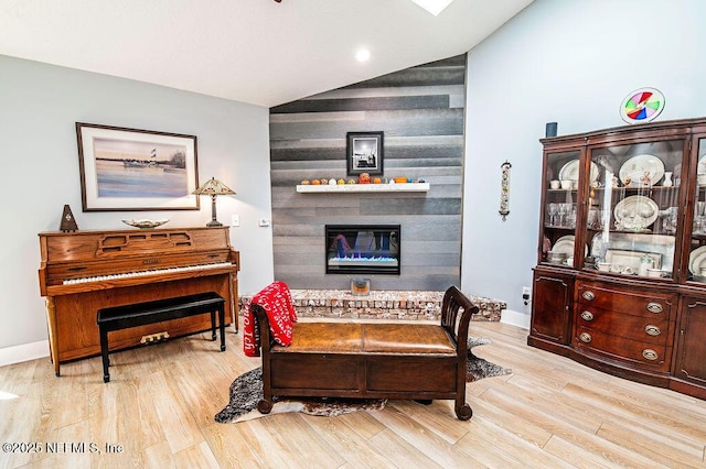 interior space featuring light hardwood / wood-style floors, a large fireplace, and lofted ceiling