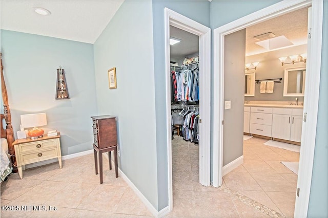 hallway with sink and light tile patterned floors