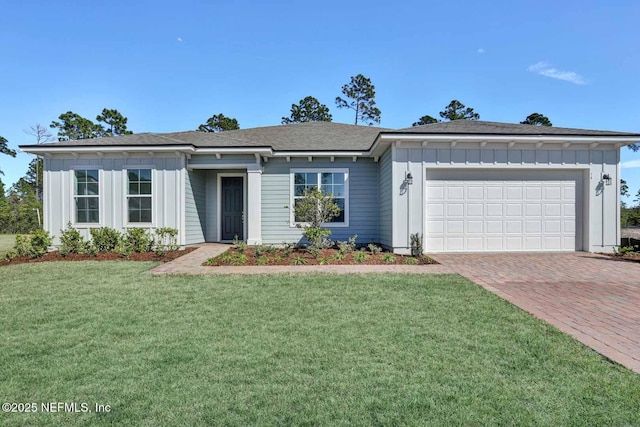 ranch-style house featuring board and batten siding, a front lawn, decorative driveway, and a garage