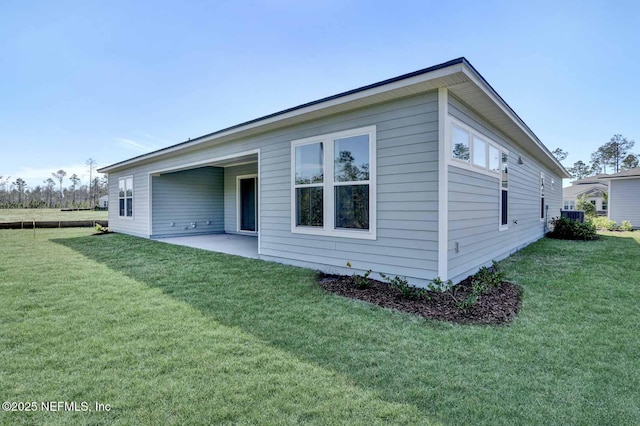 back of house featuring a lawn and a patio area